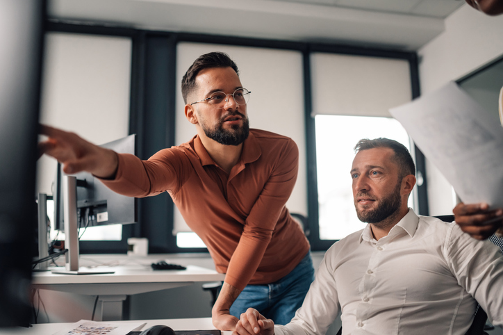 Two professionals reviewing data on a screen, working through a technical problem